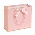 Sacchetto regalo 30 x 12 x 25 cm in carta rosa con manici in corda e fiocco decorativo